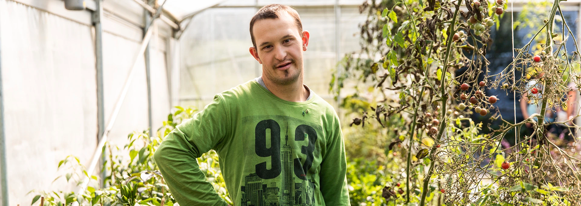 Ein junger Mann mit grünem Shirt bei der Gartenarbeit.